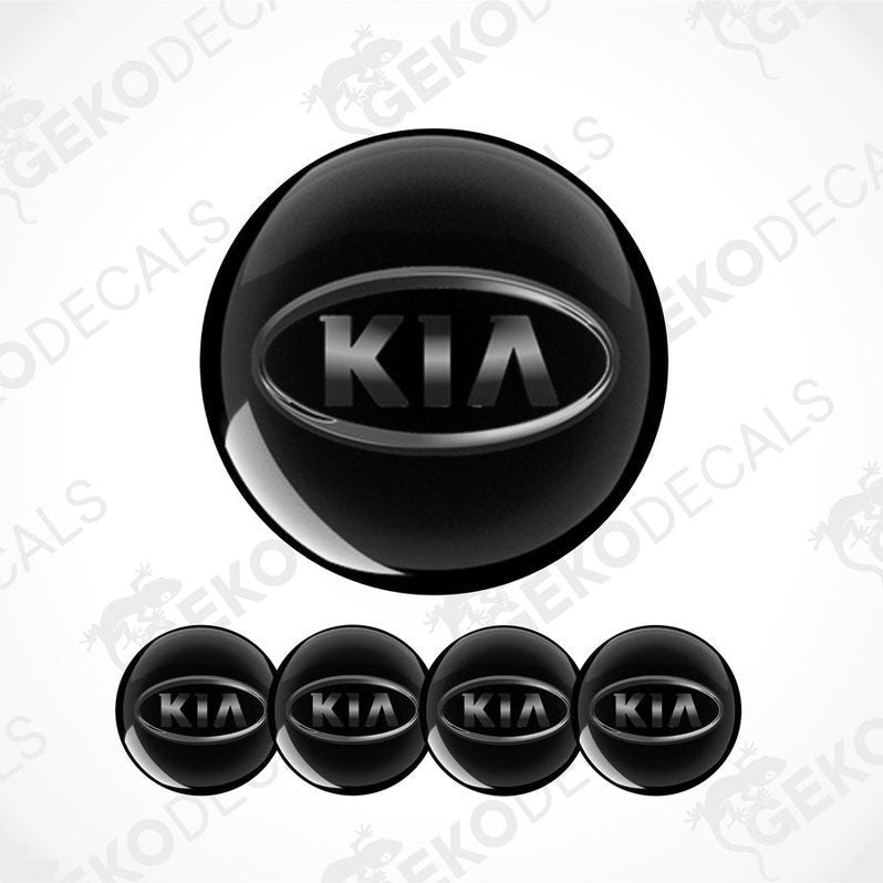 A set of four black vinyl stickers with the KIA brand logo on them.