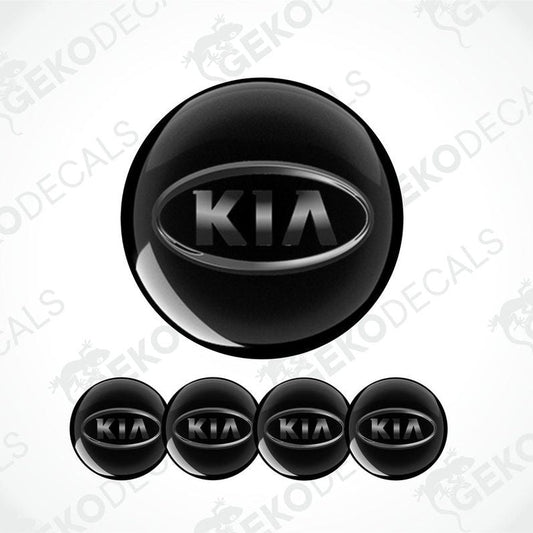 A set of four black vinyl stickers with the KIA brand logo on them.