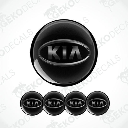 A set of four black vinyl stickers with the KIA brand logo on them.