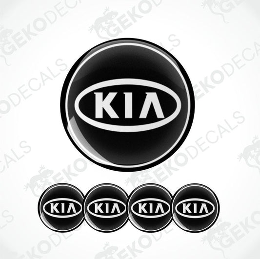 A set of four black vinyl stickers with the KIA brand logo on them.