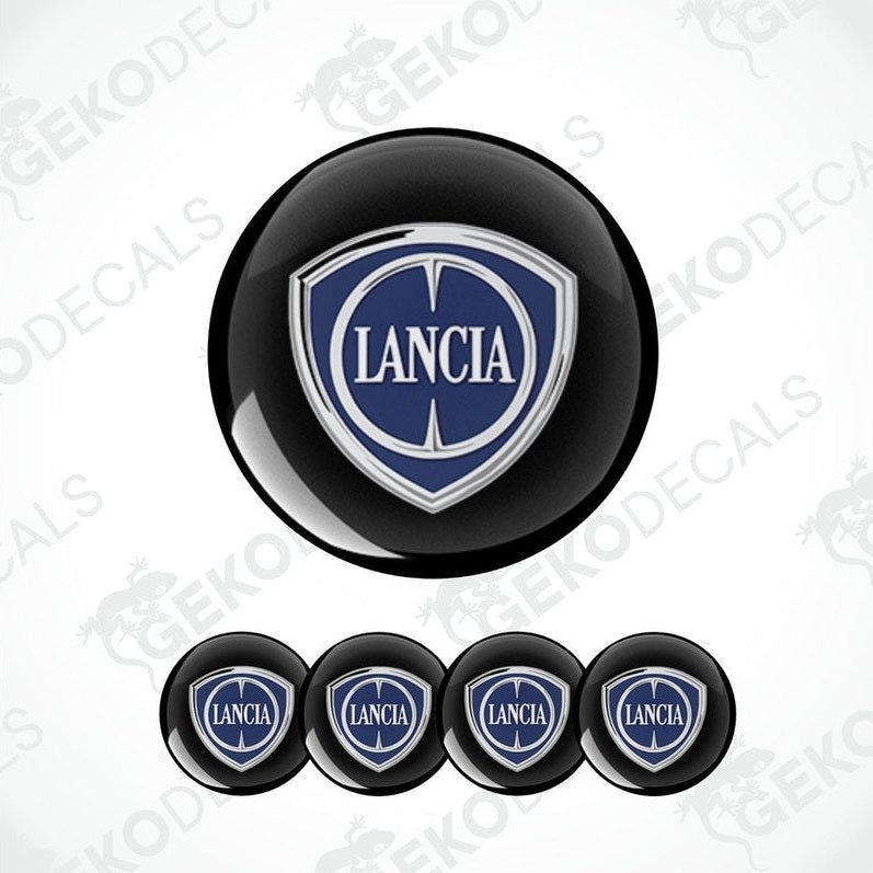 A set of four black vinyl stickers with the LANCIA brand logo in white and blue.