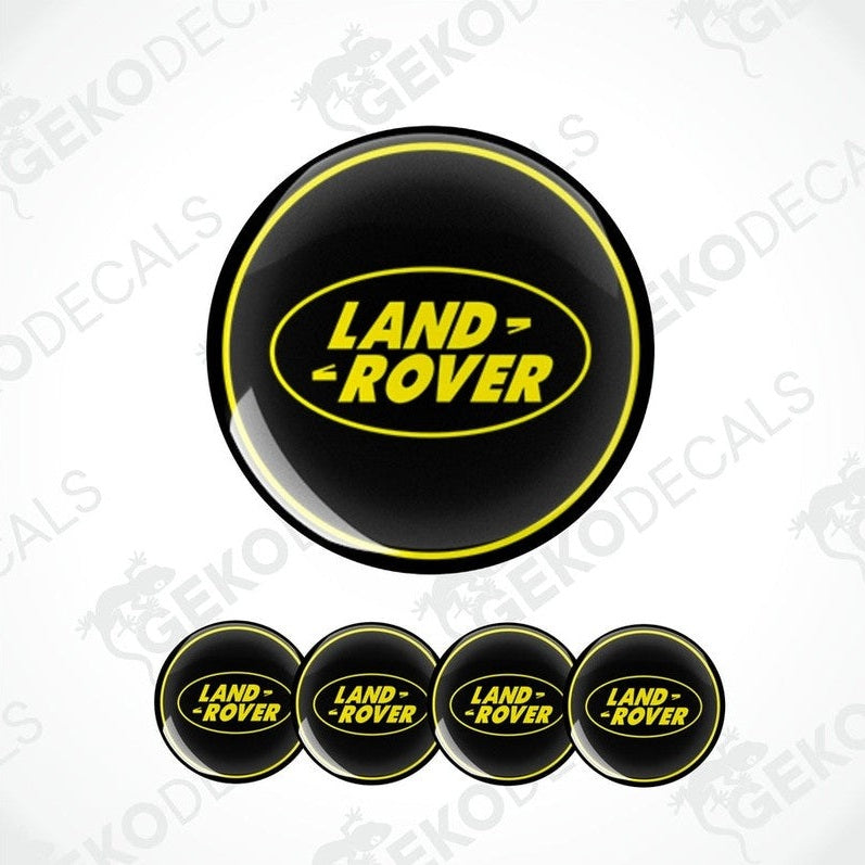 A set of four black vinyl stickers with the text 'LAND ROVER' in yellow. Each sticker has a different size, designed to fit on a car wheel.