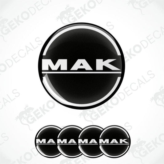 A set of black and white vinyl decals with the text 'MAK' and 'MAMAMAK' arranged in a pattern, indicative of wheel caps or car decals.