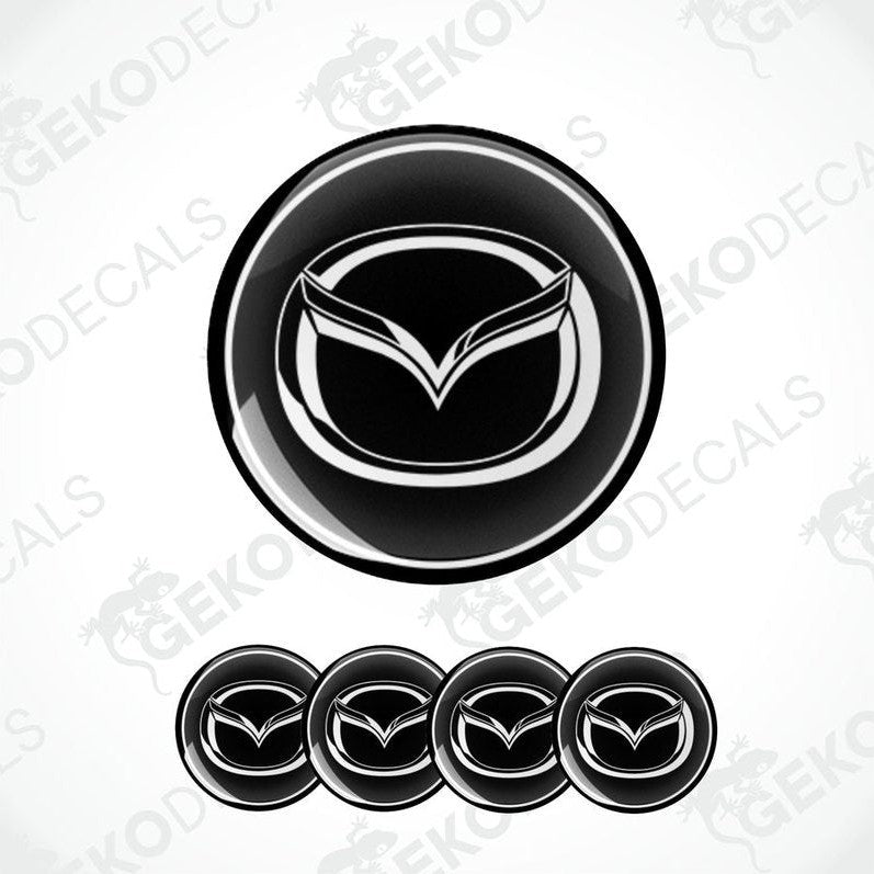 A set of four black vinyl stickers with a geometric design featuring the Mazda logo.