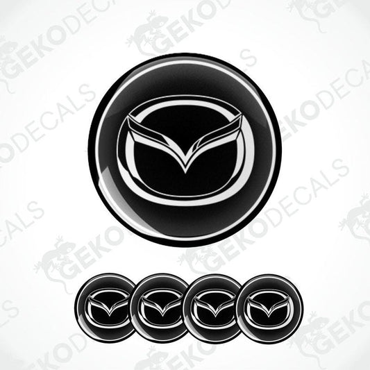 A set of four black vinyl stickers with a geometric design featuring the Mazda logo.