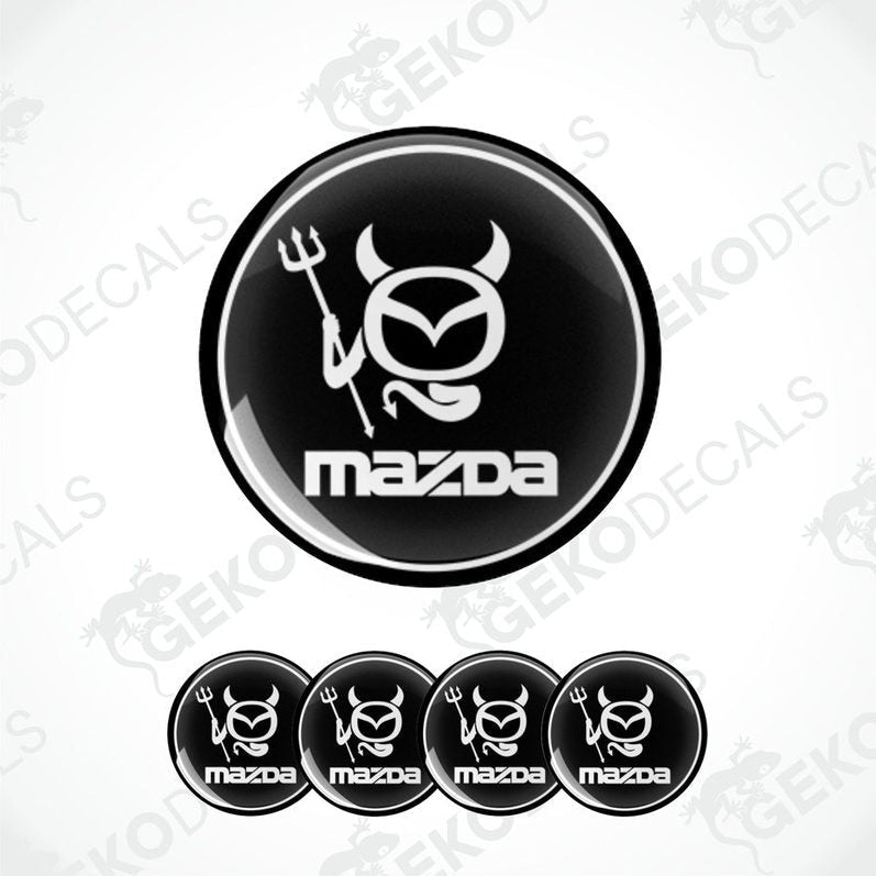 A set of black and white vinyl decals with polyurethane coating featuring a Mazda logo with a stylized horned figure.