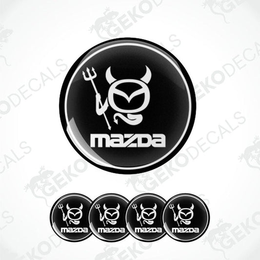 A set of black and white vinyl decals with polyurethane coating featuring a Mazda logo with a stylized horned figure.