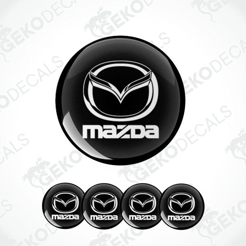 A set of four black vinyl stickers with the Mazda logo in white.