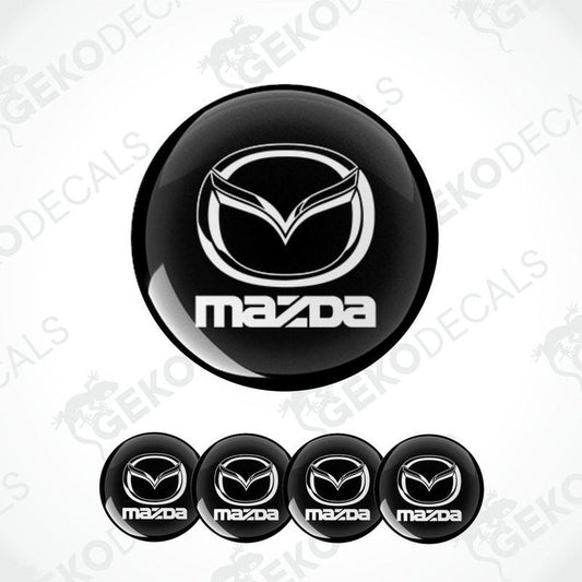 A set of four black vinyl stickers with the Mazda logo in white.