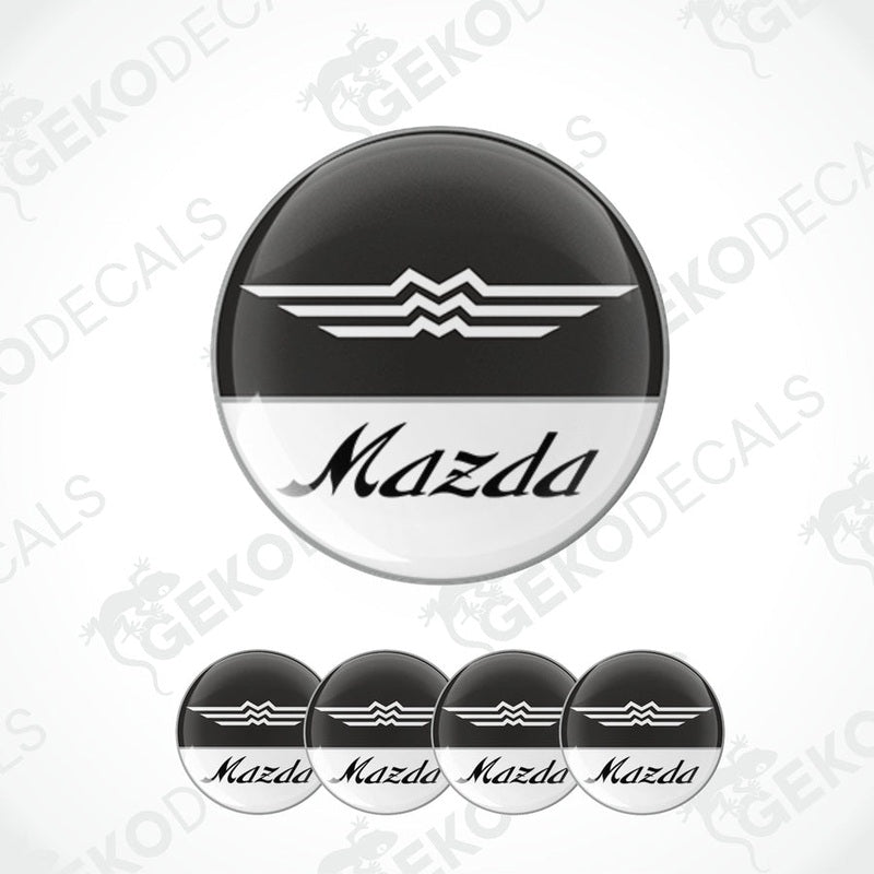 A set of four round MAZDA branded vinyl stickers with a black, white, and gray color scheme on a white background.