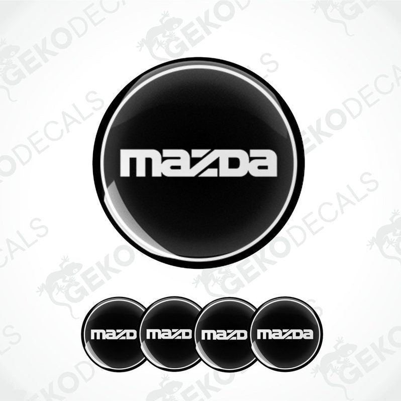 A set of four black vinyl stickers with the Mazda logo on them.