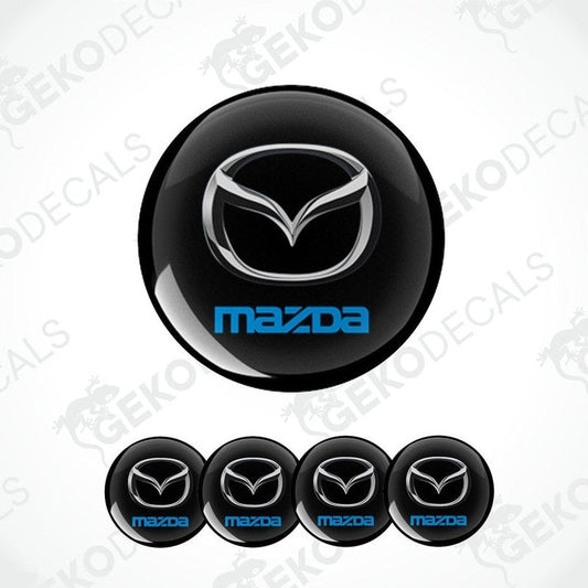 A set of black round car decals with  silver and blue Mazda logo in the center. 
