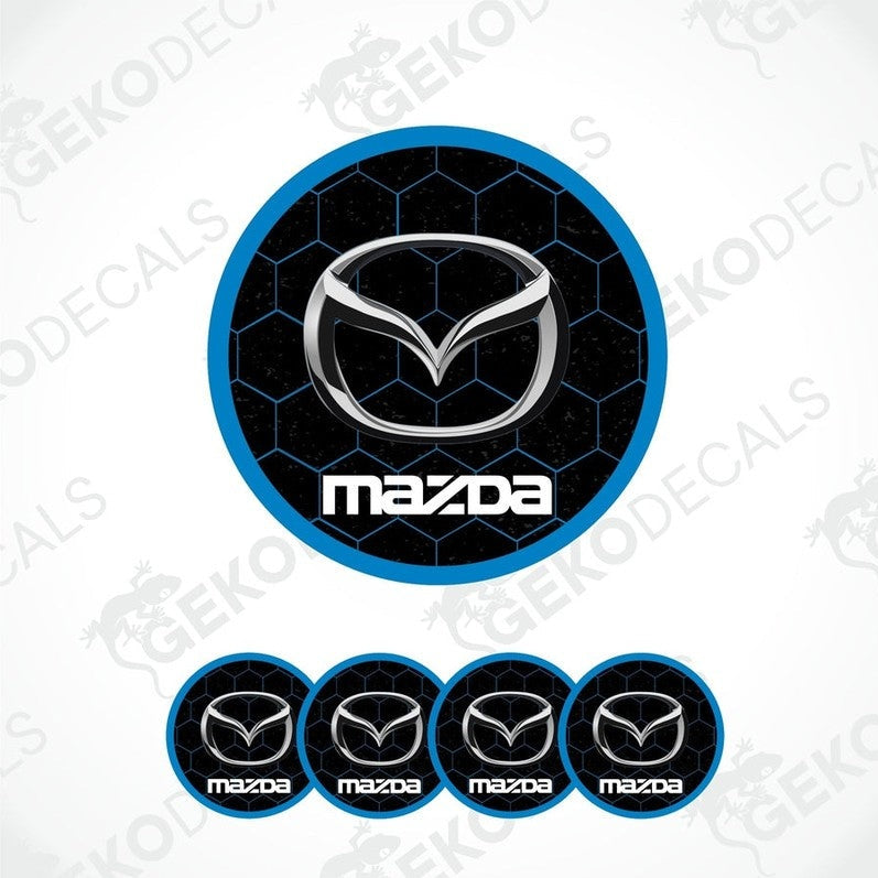 A set of four round MAZDA branded vinyl stickers with a geometric pattern and a blue and black color scheme.