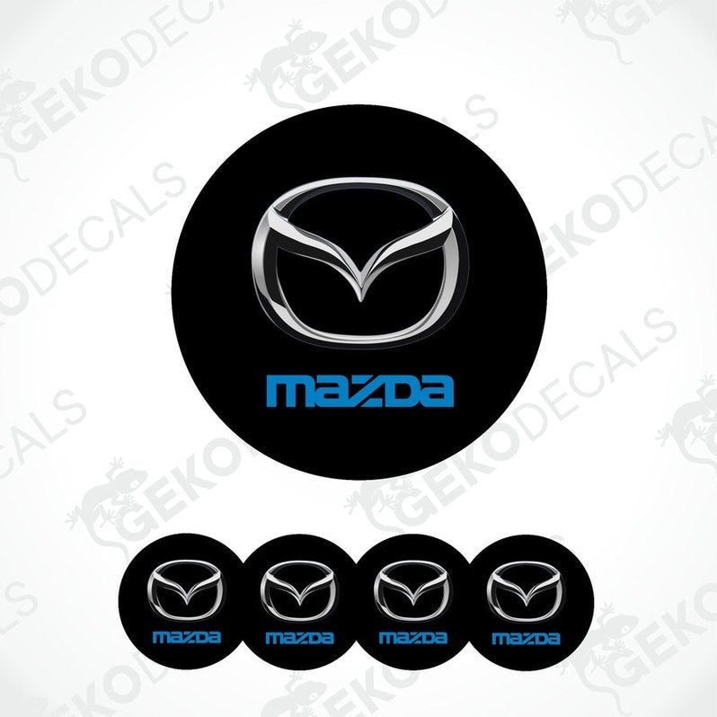 A set of black round car decals with  silver and blue Mazda logo in the center.