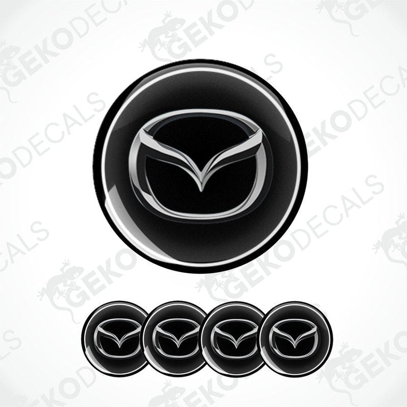 A set of four black vinyl stickers with a silver Mazda logo on each.