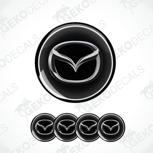 A set of four black vinyl stickers with a silver Mazda logo on each.