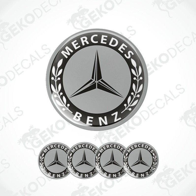 A set of four black and grey Mercedes-Benz wheel decals with a star logo in the center.