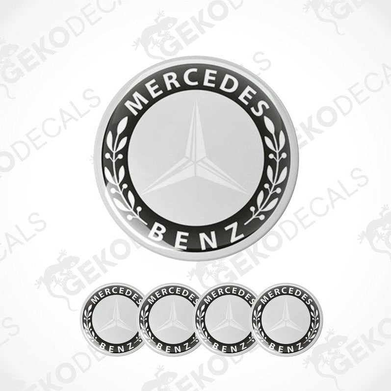 A set of four black and grey Mercedes-Benz wheel decals with a star logo in the center.