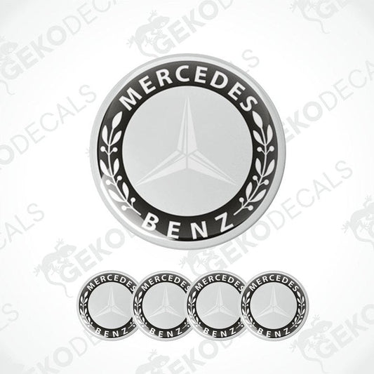 A set of four black and grey Mercedes-Benz wheel decals with a star logo in the center.