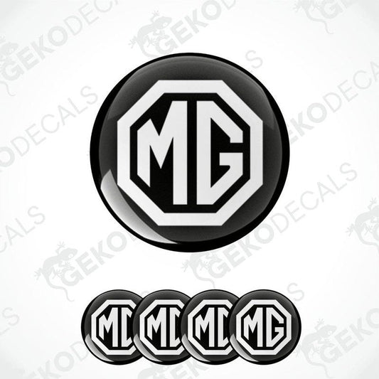 A set of four black and white vinyl decals with the MG logo, designed for use as car wheel caps or domed stickers.