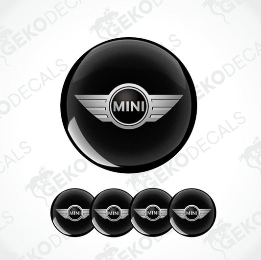 A set of four black vinyl stickers with the word 'MINI COOPR' in the center, designed to be applied on car wheels.