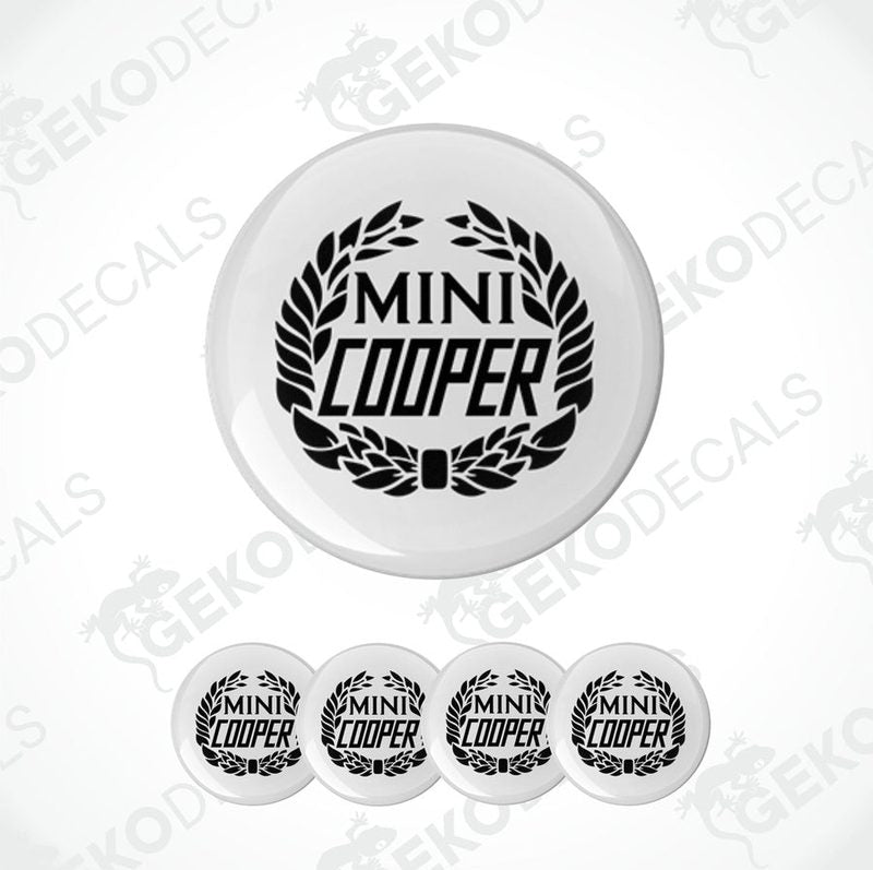 A set of four black and white vinyl decals with the text 'MINI COOPER' on them, presented against a white background.