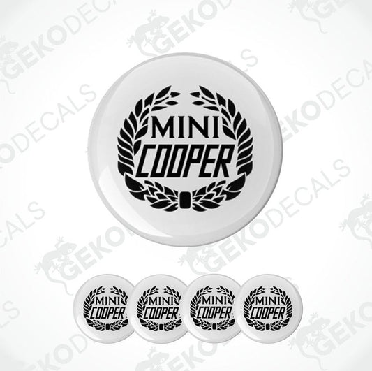 A set of four black and white vinyl decals with the text 'MINI COOPER' on them, presented against a white background.