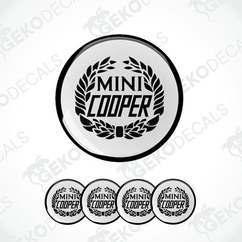A set of four black and white vinyl decals with the text 'MINI COOPER' and a laurel wreath design.