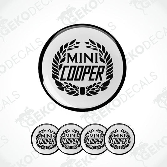 A set of four black and white vinyl decals with the text 'MINI COOPER' and a laurel wreath design.
