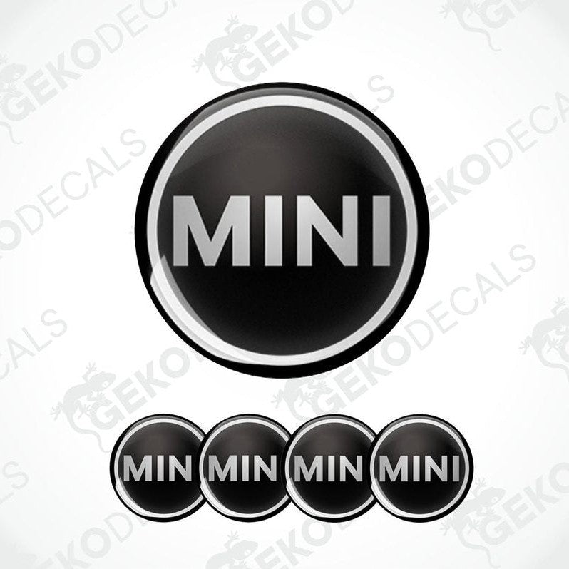 Set of four black vinyl decals with the Mini Cooper logo, designed for use on a vehicle's wheels.
