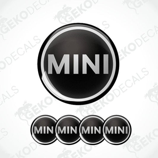 Set of four black vinyl decals with the Mini Cooper logo, designed for use on a vehicle's wheels.
