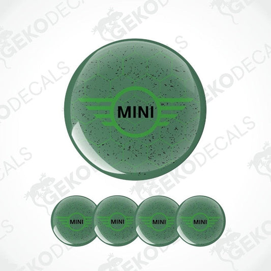 A set of four green vinyl stickers with the text 'MINI COOPER' and a graphic design resembling a stylized airplane or a winged logo.