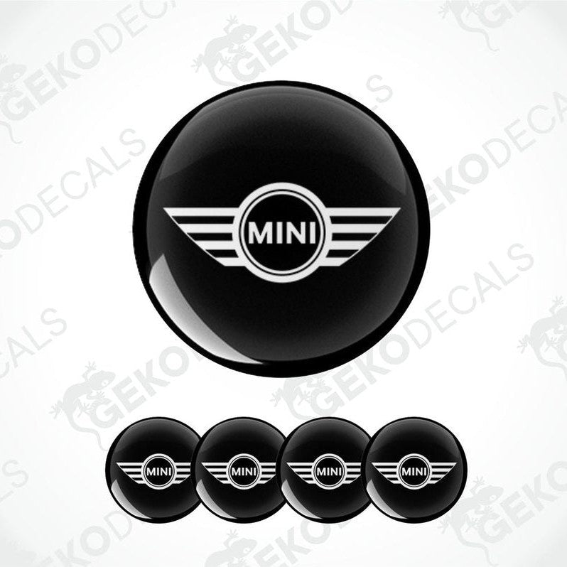 Set of four black vinyl decals with the Mini Cooper logo, designed for use on a vehicle's wheels.