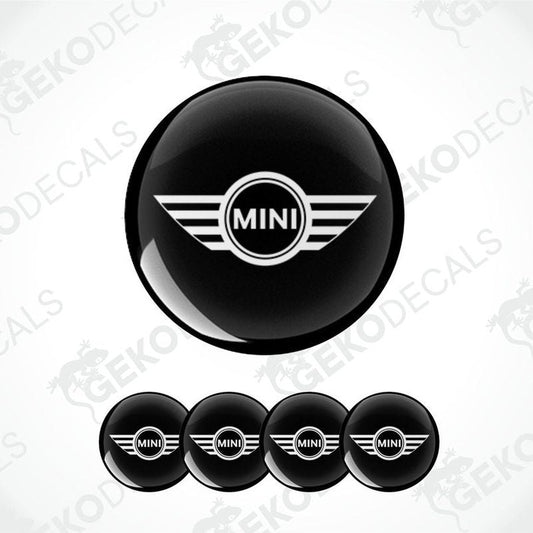Set of four black vinyl decals with the Mini Cooper logo, designed for use on a vehicle's wheels.