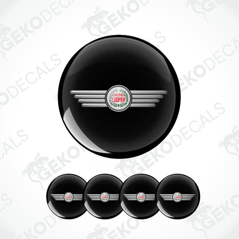 A set of black vinyl decals with a silver logo, designed for MINI COOPER vehicles, including four wheel cap decals.
