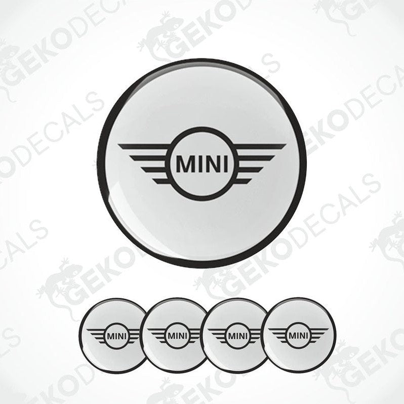 A set of round car decals for a MINI COOPER, with one large decal featuring the MINI logo and three smaller ones for wheels.