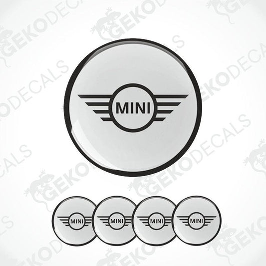 A set of round car decals for a MINI COOPER, with one large decal featuring the MINI logo and three smaller ones for wheels.