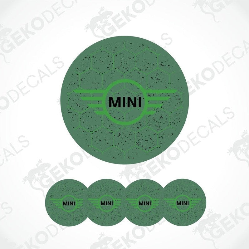 A set of four green vinyl stickers with the text 'MINI COOPER' and a graphic design resembling a stylized airplane or a winged logo.