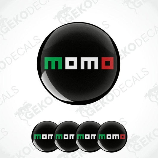A set of four round black vinyl stickers with the word 'MOMO' written on them in red and green colors.