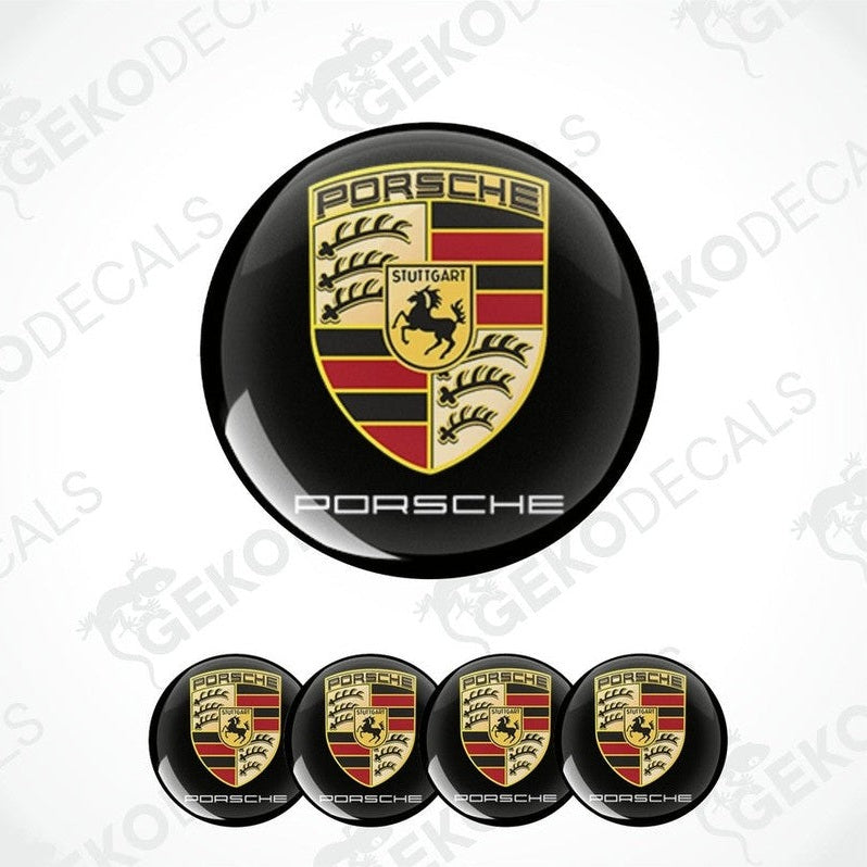 A set of four Porsche car wheel hub caps with the Porsche logo.