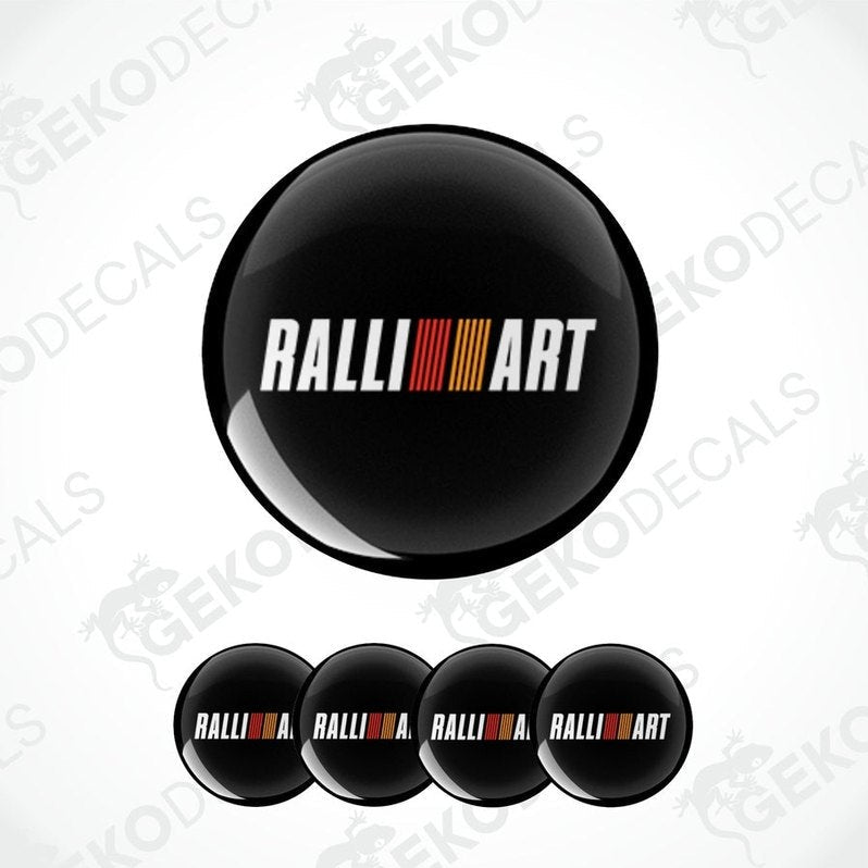 A set of four black vinyl stickers with the word 'RALLIART' printed in a colorful gradient design.