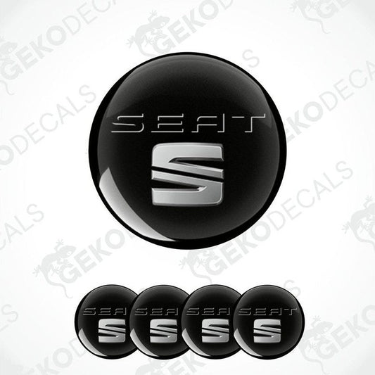 A set of four black vinyl decals with the SEAT logo in white, intended for use as car wheel caps.