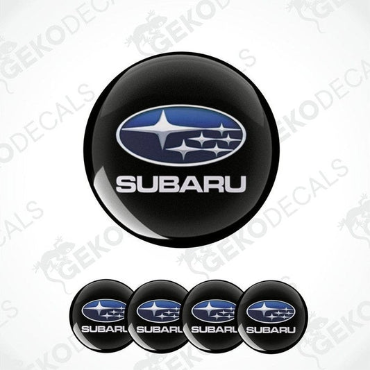 A set of four black vinyl stickers with the Subaru brand logo on them.