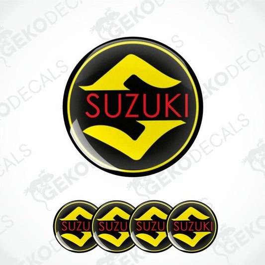 A set of four circular vinyl decals with the SUZUKI logo in black, yellow, and red colors.