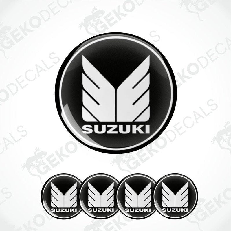 A set of four black vinyl stickers with the SUZUKI brand logo.