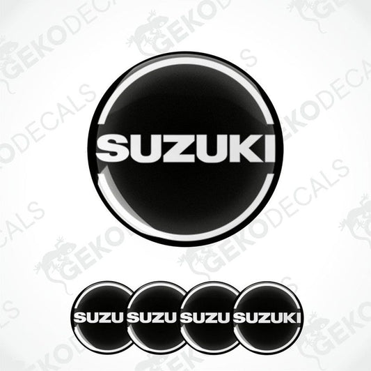 A set of four black and white vinyl stickers with the word 'SUZUKI' in bold letters, designed for use on car decals or wheel caps.