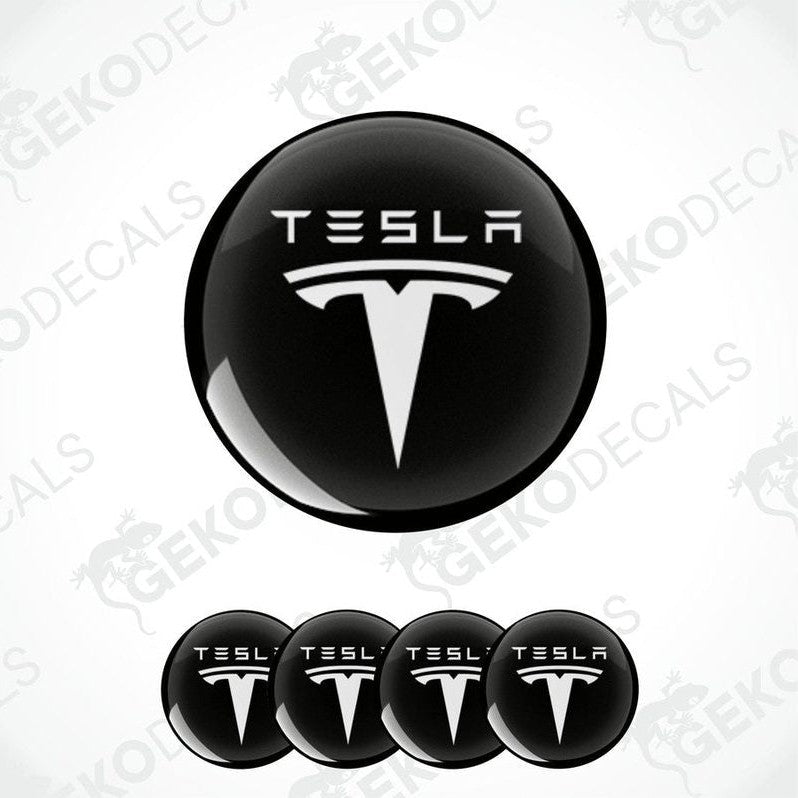 Set of four black and white vinyl decals with the Tesla logo, intended for use on a vehicle's wheels and other surfaces.