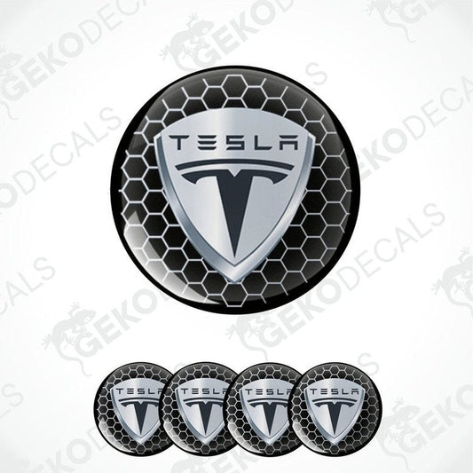 A set of four round Tesla branded vinyl stickers with a geometric pattern in black, white, and gray colors.