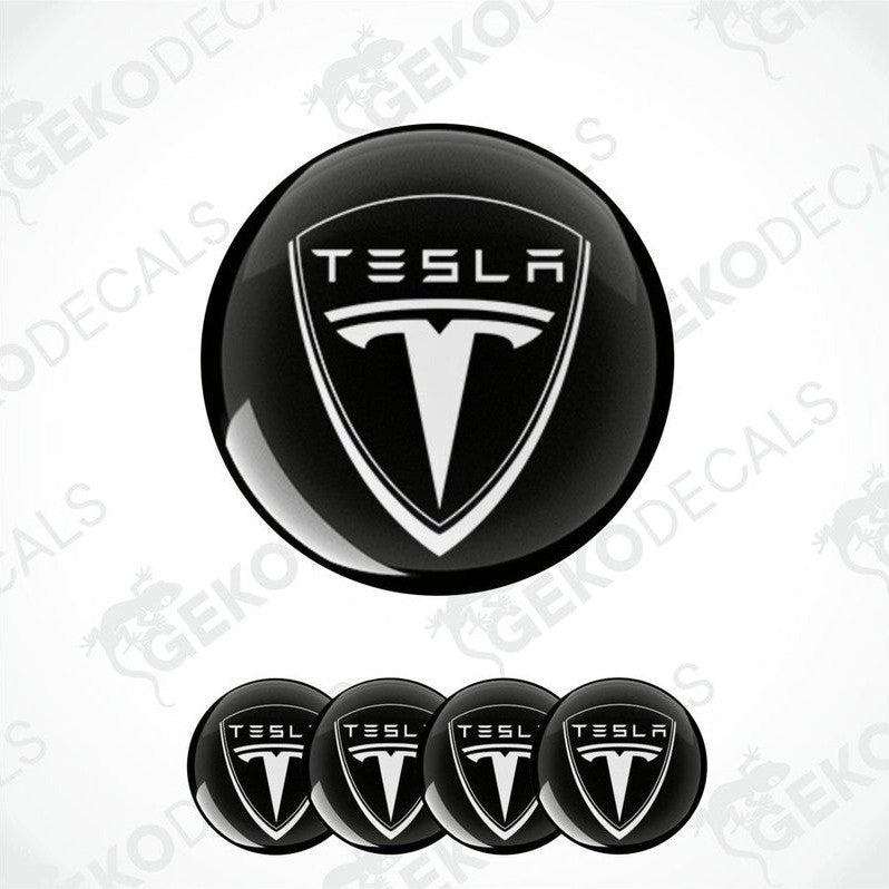 A set of four black vinyl stickers with a Tesla logo design.