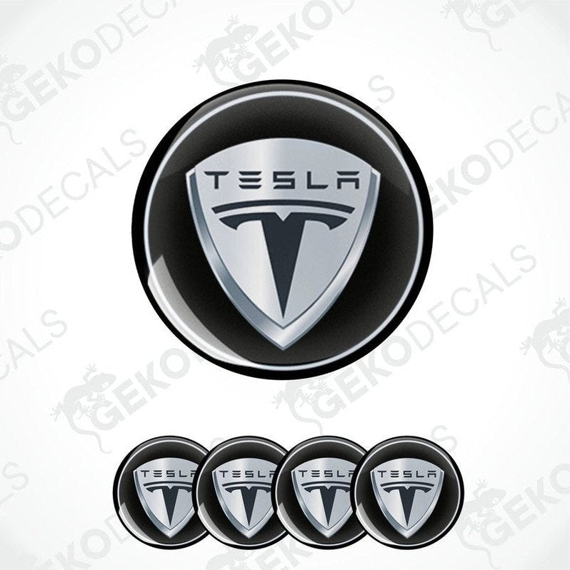 A set of four round black vinyl stickers with the Tesla brand logo in the center.